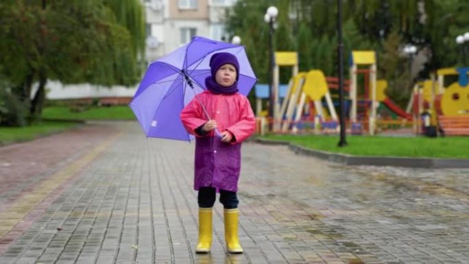 在秋雨中玩耍的孩子。带伞的孩子。任何天气下的户外乐趣。儿童防雨服、靴子和夹克