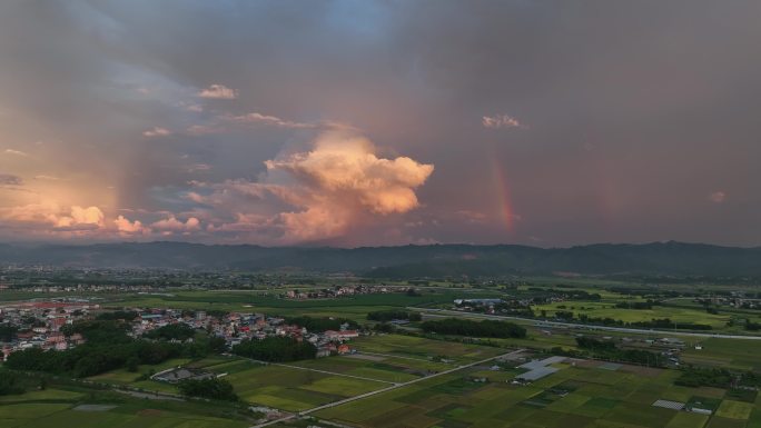 傍晚时分双道彩虹映照田野和村庄