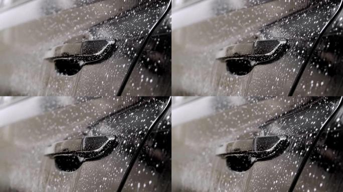 泡沫慢慢从门上流下。洗车豪华黑色汽车
