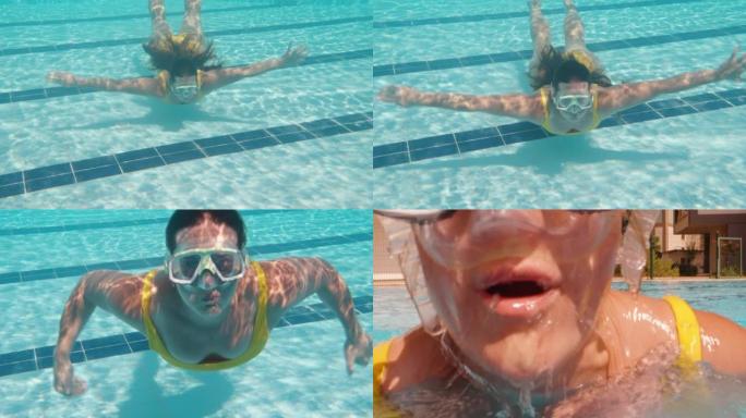 一个穿着黄色泳衣和面具的胖乎乎的女孩从镜头前的水下弹出。游泳池和水下相机。慢动作