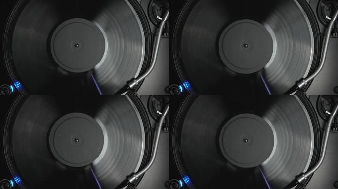 DJ转盘播放模拟唱片。转盘针在旋转乙烯基光盘与音乐。从4k上方拍摄的唱片骑师音频设备