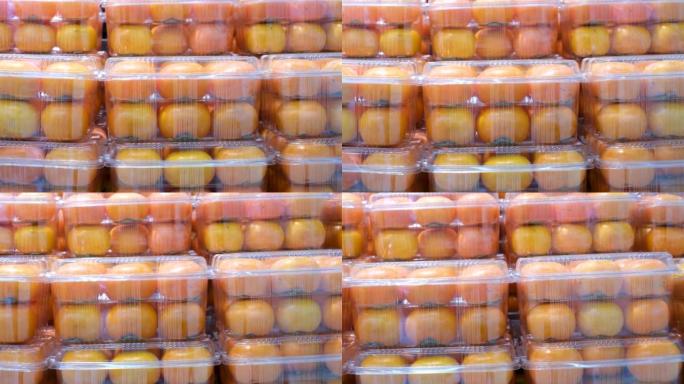 塑料容器中的成熟柿子在超市里特写镜头。