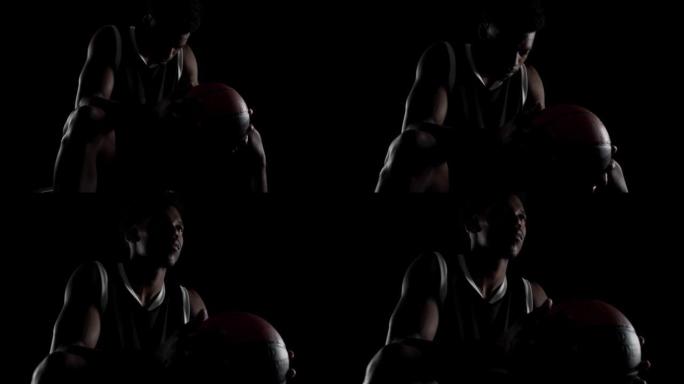 坐在长凳上的篮球运动员。黑人背景下的非裔美国体育人。