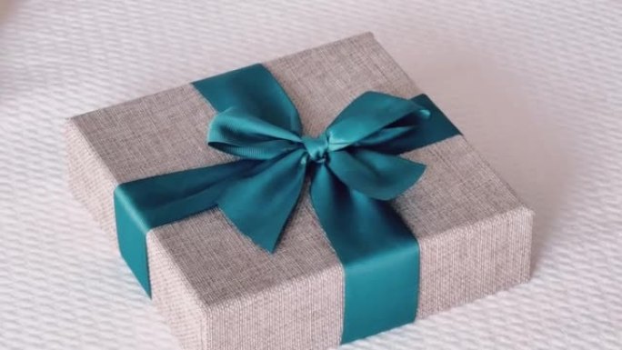 节日礼物和豪华网上购物送货，卧室床上蓝色丝带包裹亚麻礼品盒，别致的乡村风格
