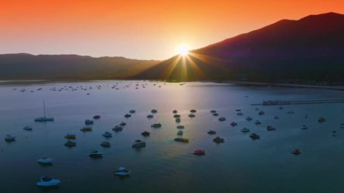 日落时太浩湖上空明亮的橙色天空。许多船从水中欣赏日落的景色。鸟瞰图。