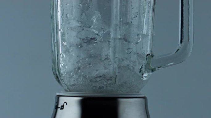 搅拌机粉碎冰块特写。鸡尾酒搅拌机饮料研磨立方体