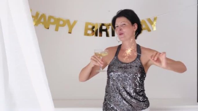 快乐的中年妇女庆祝生日和喝香槟。