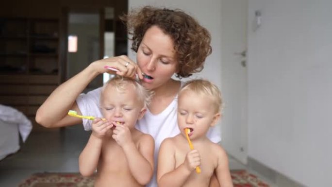 单身妈妈的挑战是教她的双胞胎幼儿通过刷牙来照顾他们的个人卫生。对于一个独自抚养两个孩子的单身母亲来说