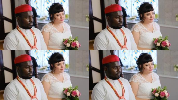穿着白色婚纱的非洲新郎和白人白人妇女的婚礼