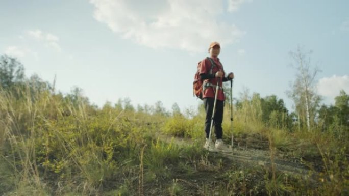 亚洲女游客用登山杖徒步旅行