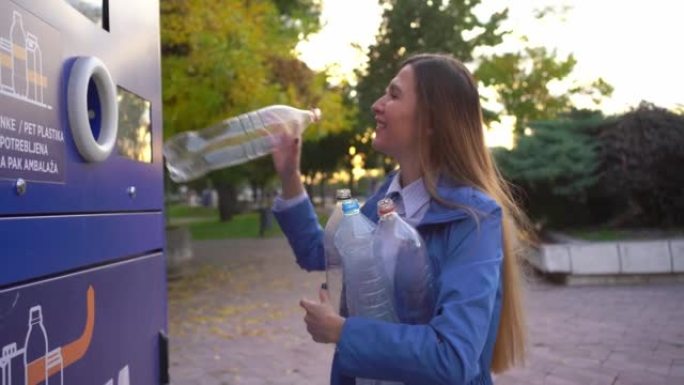 女人在机器中回收塑料瓶