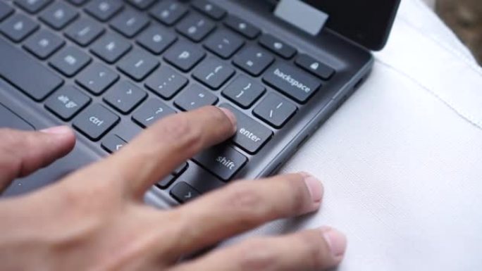 用食指按笔记本电脑键盘上的enter键。