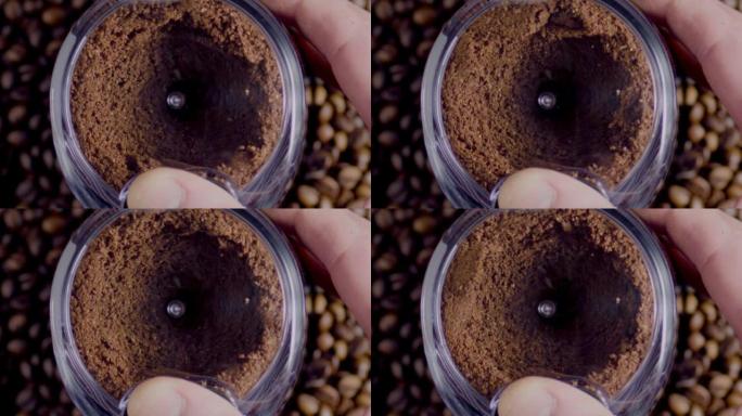 俯视图电动研磨机准备咖啡粉特写。地面种子旋转