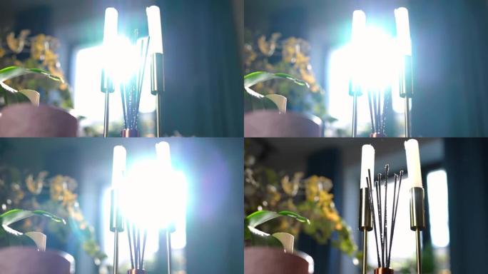 当现场摄像机从左到右平移时，阳光以慢动作透过家用香水棒和烛台照耀。在阳光下的室内特写家庭装饰品。