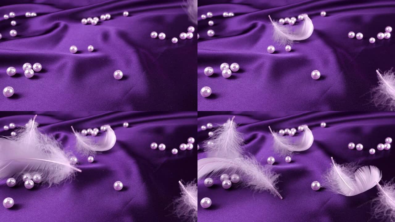 白天鹅羽毛落在紫罗兰色的丝绸上，珍珠。慢动作。