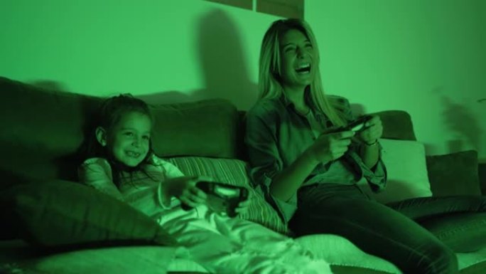 女人在家里和小女孩在一起玩电子游戏