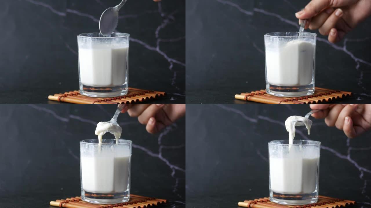 一杯全脂牛奶放在桌子上，奶油牛奶。