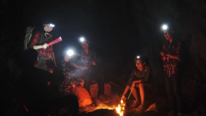 一群年轻人在黑暗中的篝火旁野餐