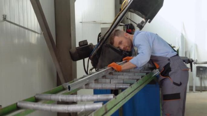 体力劳动者在一家工厂工作，他正在组装PVC门窗。铝和聚氯乙烯门窗生产