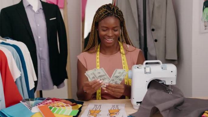 非裔美国女裁缝微笑着自信地在裁缝店数钱