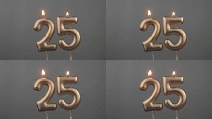 在灰色背景上燃烧金色生日蜡烛，编号25