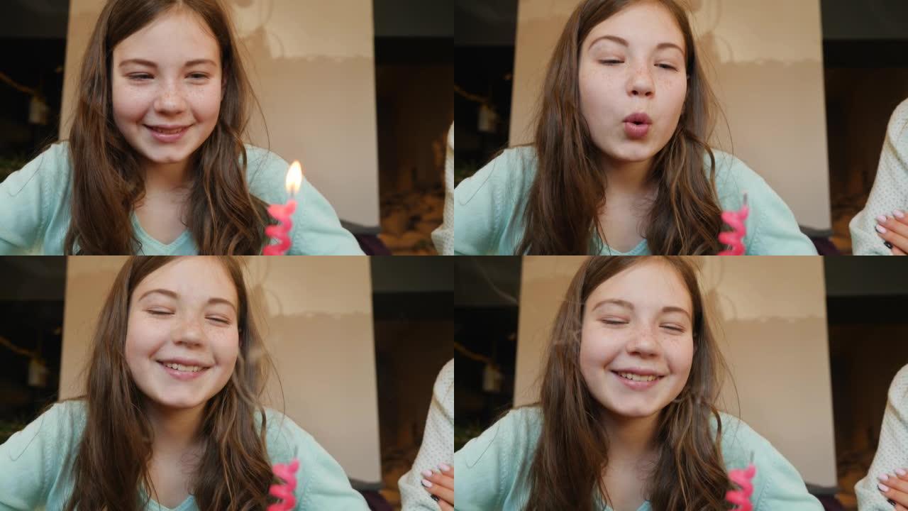 快乐的小女孩少年庆祝生日，在微笑的蛋糕上吹灭蜡烛