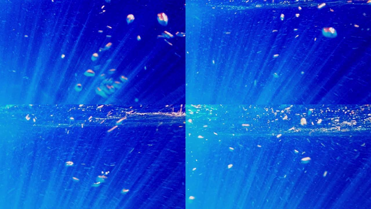 水下深蓝色的海水和带有气泡的光线向上移动到海面。慢动作