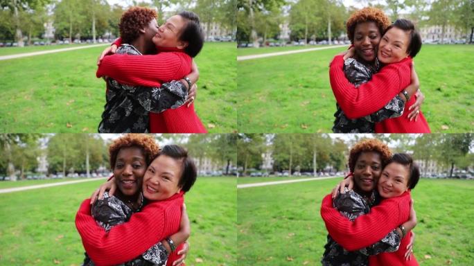 两个女性朋友在公园里互相拥抱，是幸福，多样性和团结的概念。