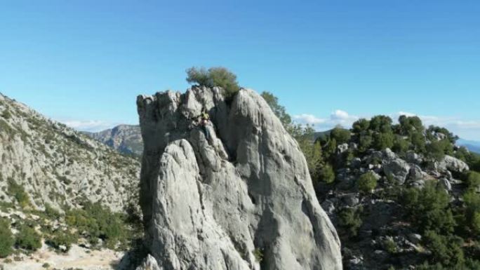 无人机视角:一位成功的登山领袖正在用绳索和技术设备在落基山脉上攀登并稳固自己的位置