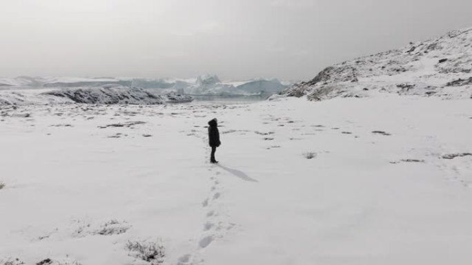 一个孤独的人在雪地里四处张望的轨道镜头