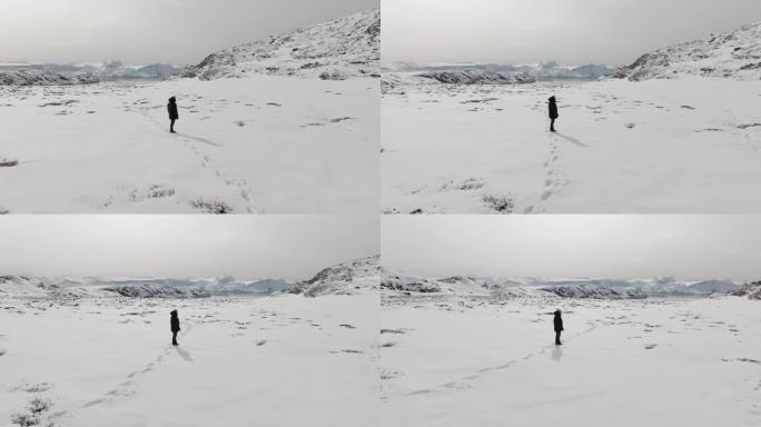 一个孤独的人在雪地里四处张望的轨道镜头