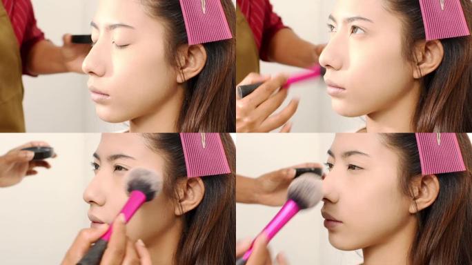 年轻美丽的亚洲女性由化妆师化妆。