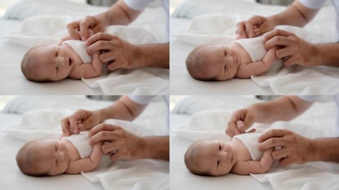 Father holding hands of newborn baby