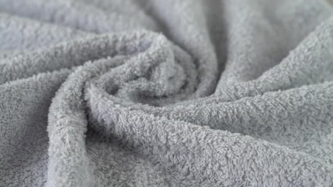 灰色棉布毛圈毛巾在船上旋转。沐浴、卫生、洗涤和清洁概念。纺织业