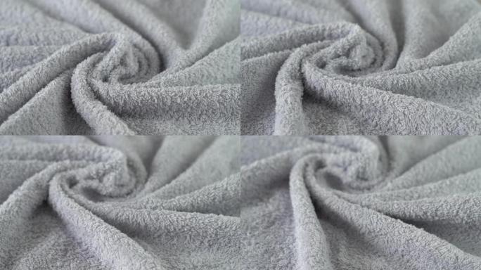 灰色棉布毛圈毛巾在船上旋转。沐浴、卫生、洗涤和清洁概念。纺织业