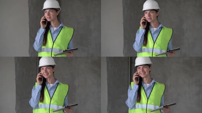 在室内使用平板电脑并在手机上聊天的建筑工地上从事项目的女工程师