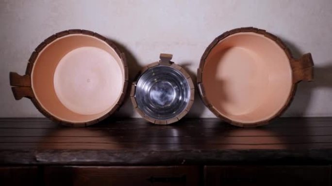 金属桶，木柄和钢包放在俄罗斯浴室的木架子上。