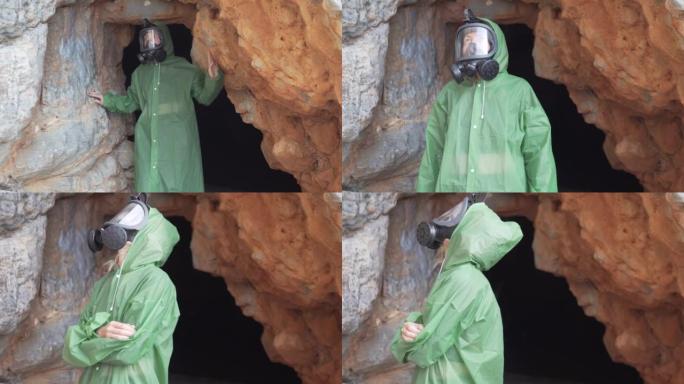一个戴着防毒面具和防护斗篷的女人从一个黑暗的洞穴中出现在灯光下