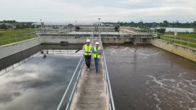 两名环境工程师在废水处理厂工作，水管理概念。