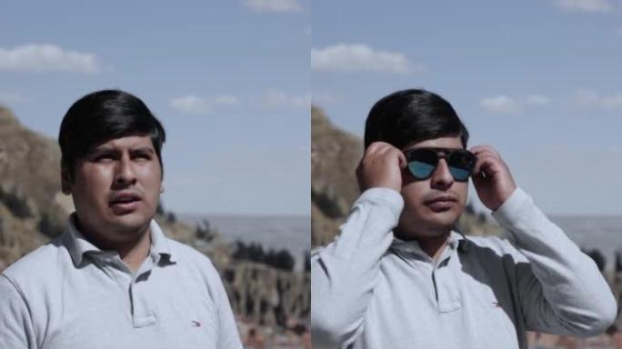 一个西班牙裔男子戴上太阳镜的垂直镜头