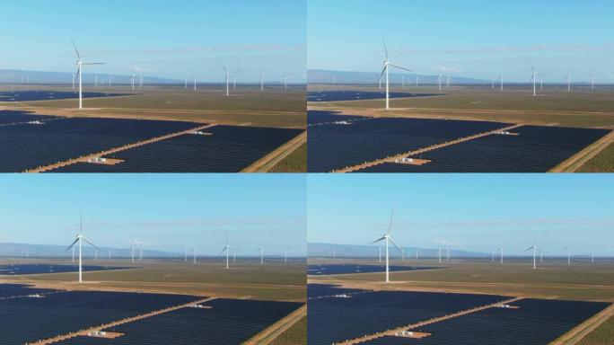 前景广阔的大型太阳能发电场旋转的鸟瞰图风力涡轮机