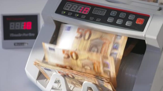 电子点钞机计数五十欧元纸币。数字在模糊的背景下在柜台显示器上快速变化。特写。