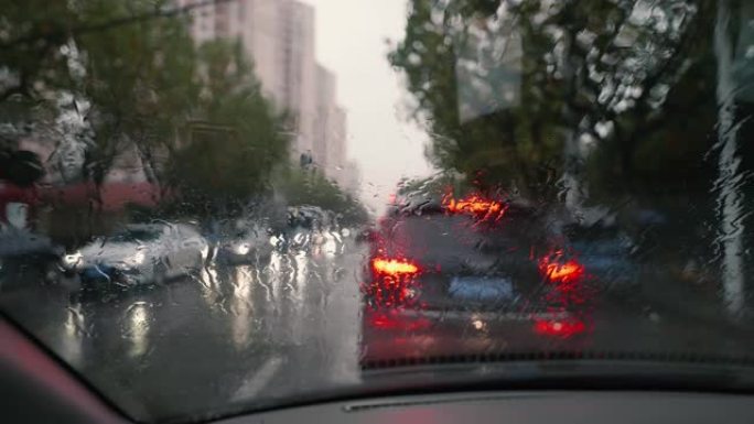 雨天排队等候的汽车，重点关注落在前窗的雨滴，4k慢动作镜头，城市生活概念。