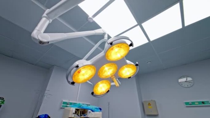 手术室天花板上有黄色灯的活动灯。在手术室中盘旋照明镜头。低角度视图。