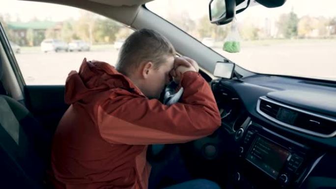 司机小睡了一会儿，把头靠在汽车的方向盘上。