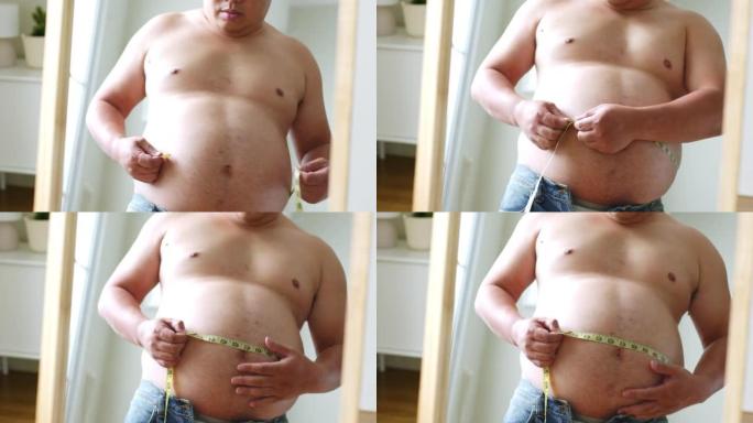 亚洲胖子照镜子看身体，测量腰围和腹部