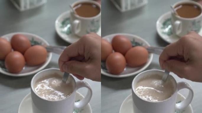 男子搅拌热燕麦饮料，在咖啡馆吃健康早餐。