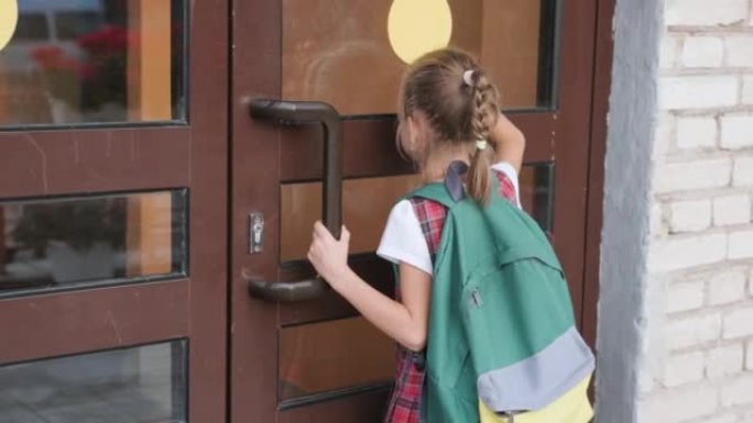 一个背着背包的女学生专心地看着学校的窗外