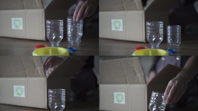 成年妇女将塑料瓶扔进厨房的回收箱