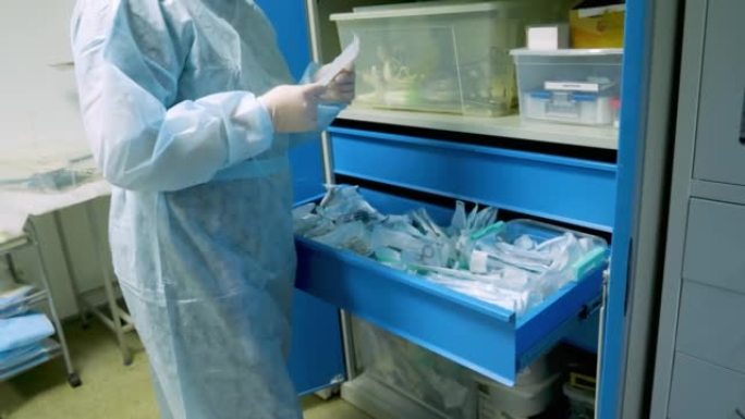 戴着手套的医生的手布置了装在真空袋中的无菌手术器械。用手清洁盒子里的消毒工具。外科器械灭菌的概念。
